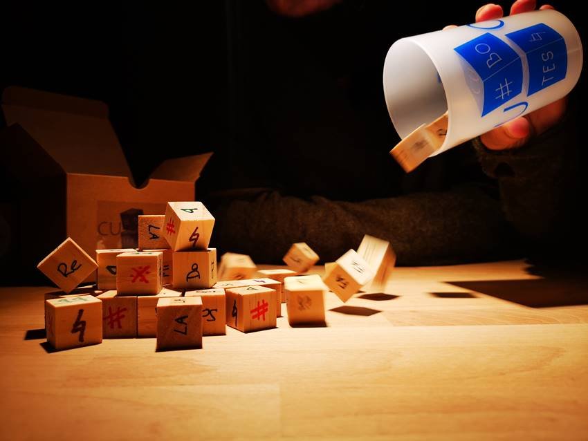Los dados y el vaso que forman el juego Cubotes.